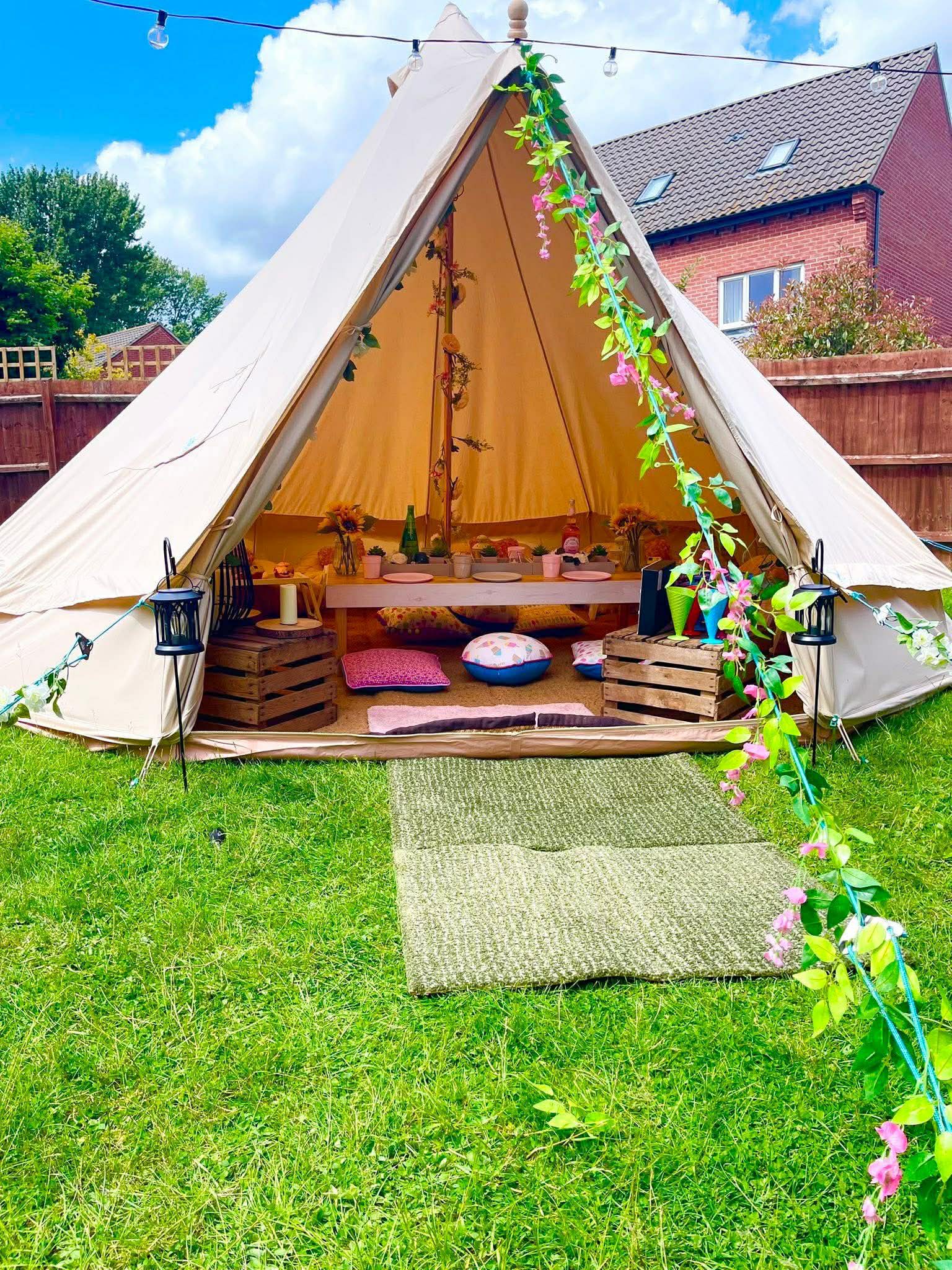 Luxe bundle bell tent exterior with flower garland and lanterns